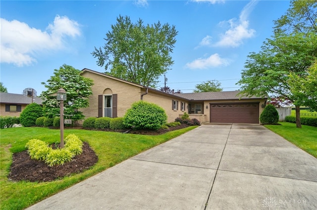 348 Cambridge Dr, Fairborn, OH 45324 - view of front of property with an attached garage, concrete driveway, a front lawn, and brick siding