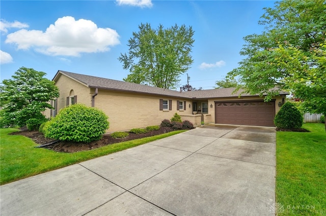 348 Cambridge Dr, Fairborn, OH 45324 - ranch-style home featuring an attached garage, concrete driveway, a front yard, and brick siding