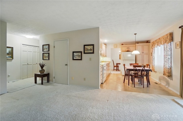 348 Cambridge Dr, Fairborn, OH 45324 - dining area featuring light carpet, baseboards, and a textured ceiling
