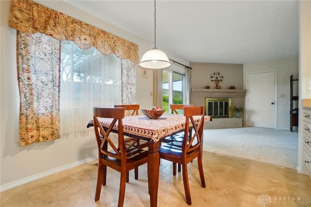 348 Cambridge Dr, Fairborn, OH 45324 - dining space featuring a fireplace, baseboards, and light carpet