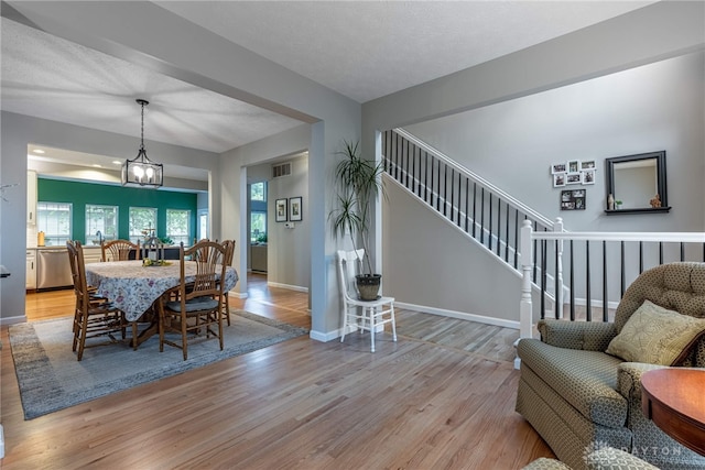 989 Brooke Ln, Xenia, OH 45385 - dining room featuring light wood finished floors, stairway, baseboards, and a chandelier