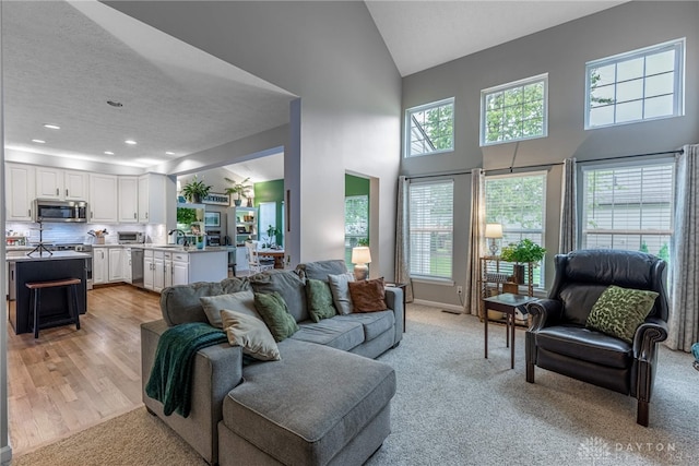989 Brooke Ln, Xenia, OH 45385 - living room with high vaulted ceiling, recessed lighting, light carpet, and light wood-type flooring
