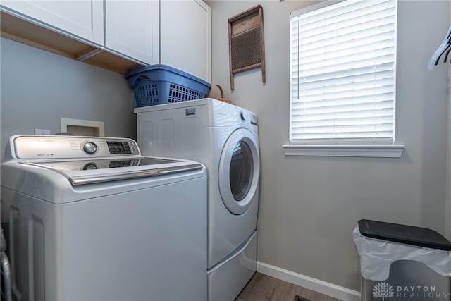 989 Brooke Ln, Xenia, OH 45385 - washroom with cabinet space, separate washer and dryer, light wood-style floors, and baseboards