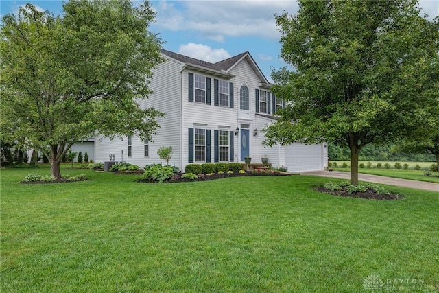 989 Brooke Ln, Xenia, OH 45385 - colonial home featuring concrete driveway, a front lawn, an attached garage, and central AC