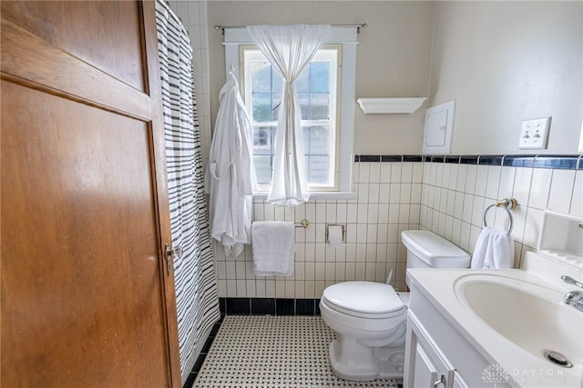 54 Beverly Pl, Oakwood, OH 45419 - bathroom with tile walls, toilet, tile patterned floors, vanity, and wainscoting