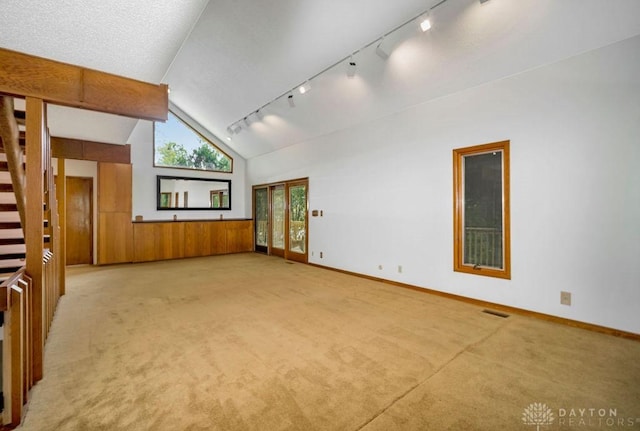 4723 Rosedale Rd, Middletown, OH 45042 - empty room with track lighting, light colored carpet, vaulted ceiling, stairway, and baseboards
