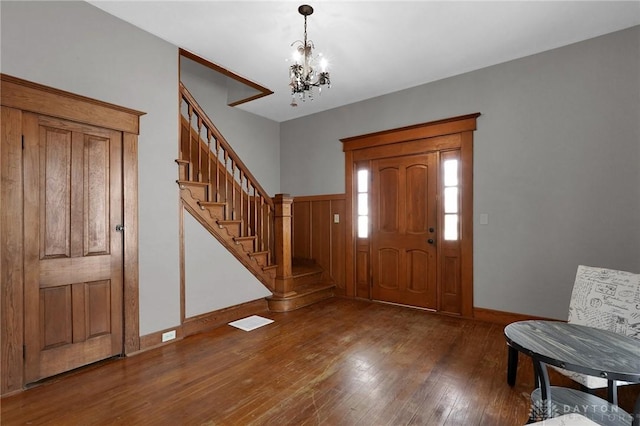 125 W Mound St, South Charleston, OH 45368 - entrance foyer featuring wood-type flooring, a chandelier, stairs, and baseboards