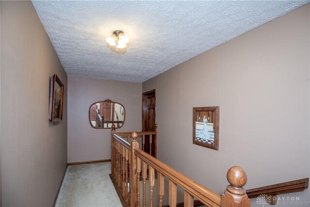 343 White Oak Dr, Chester Twp, OH 45177 - hall with an upstairs landing, a textured ceiling, light carpet, and baseboards