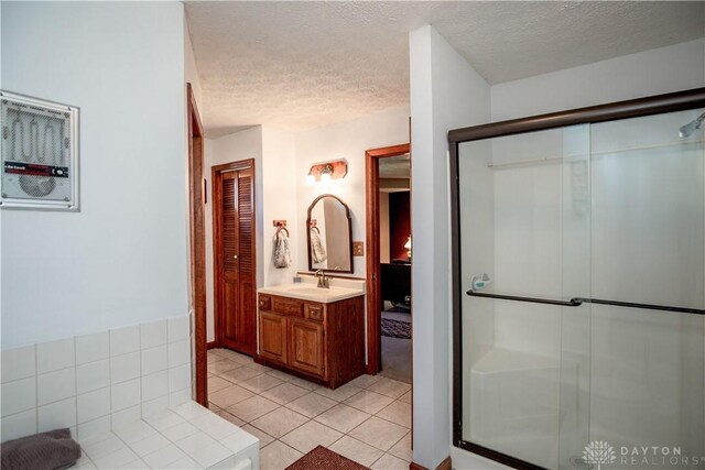 343 White Oak Dr, Chester Twp, OH 45177 - full bath with vanity, a textured ceiling, a stall shower, and tile patterned floors