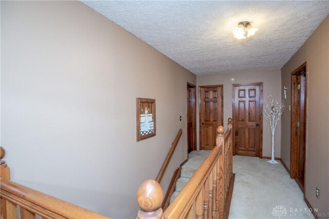 343 White Oak Dr, Chester Twp, OH 45177 - hall featuring an upstairs landing, light colored carpet, a textured ceiling, and baseboards