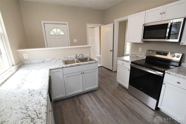 1716 Xenia Ave, Dayton, OH 45410 - kitchen with stainless steel appliances, dark wood-type flooring, plenty of natural light, a sink, and a textured ceiling