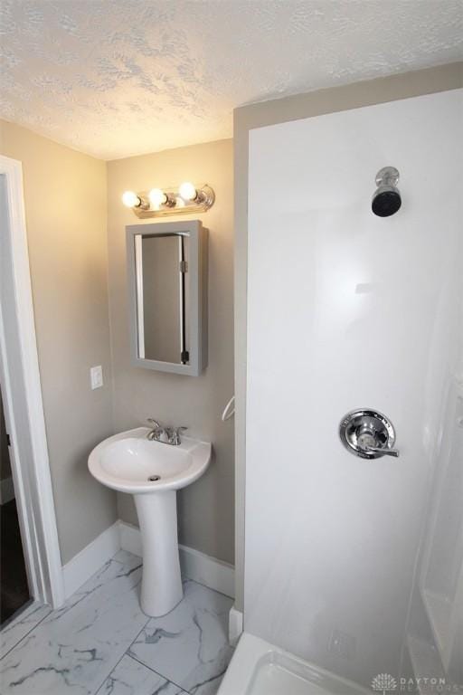 1716 Xenia Ave, Dayton, OH 45410 - bathroom featuring baseboards, a shower, marble finish floors, and a textured ceiling