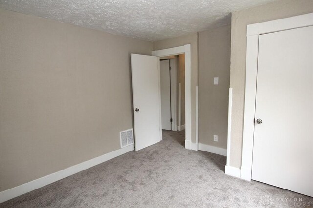 1716 Xenia Ave, Dayton, OH 45410 - unfurnished bedroom featuring carpet, a textured ceiling, baseboards, and a closet