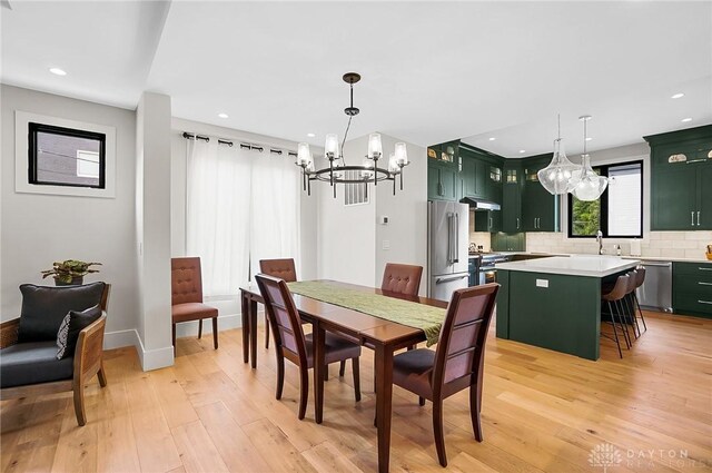 1000 Paradrome St, Cincinnati, OH 45202 - dining area with a chandelier, light wood-style floors, recessed lighting, and baseboards