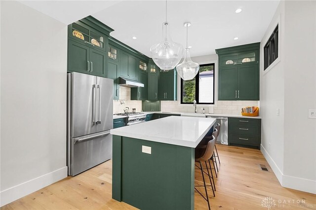1000 Paradrome St, Cincinnati, OH 45202 - kitchen with green cabinets, premium appliances, under cabinet range hood, baseboards, and a sink