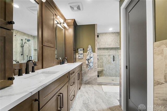 1000 Paradrome St, Cincinnati, OH 45202 - bathroom with marble look tiles, double vanity, tile walls, a shower stall, and recessed lighting