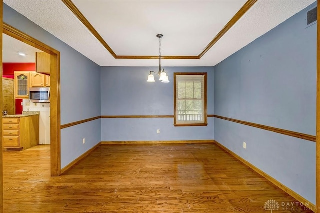 1235 Bruton Parish Way, Fairfield, OH 45014 - unfurnished room with a chandelier, light wood-type flooring, and a tray ceiling