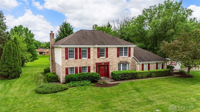 1747 Maple Ln, Beavercreek, OH 45432 - colonial home with a chimney, a front yard, and brick siding