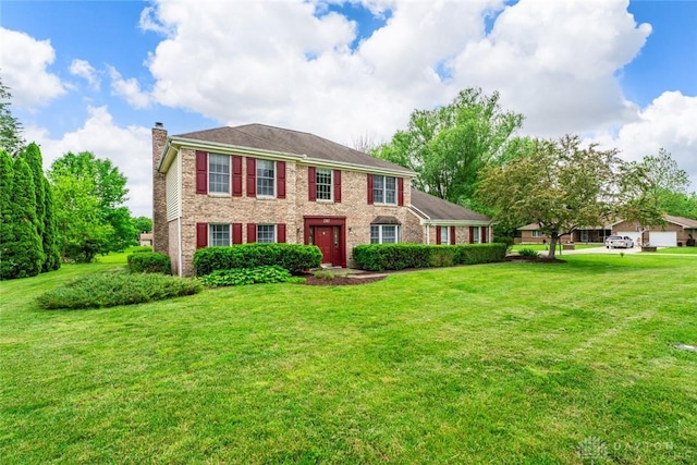 1747 Maple Ln, Beavercreek, OH 45432 - colonial home featuring a chimney, brick siding, and a front lawn