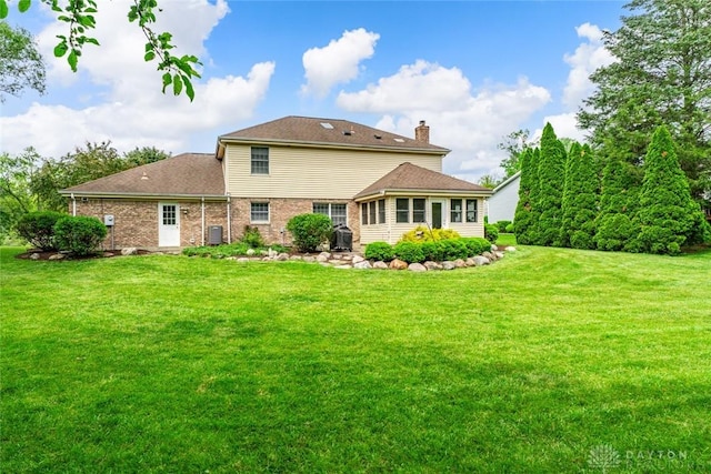 1747 Maple Ln, Beavercreek, OH 45432 - rear view of house with a lawn, a chimney, and brick siding