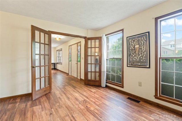 1747 Maple Ln, Beavercreek, OH 45432 - unfurnished room featuring french doors, wood finished floors, baseboards, and healthy amount of natural light