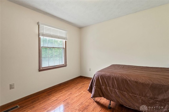 1747 Maple Ln, Beavercreek, OH 45432 - bedroom featuring wood finished floors, baseboards, and a textured ceiling