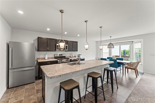 1130 Arden Way, Fairborn, OH 45324 - kitchen with stainless steel appliances, a sink, a breakfast bar, dark brown cabinets, and baseboards