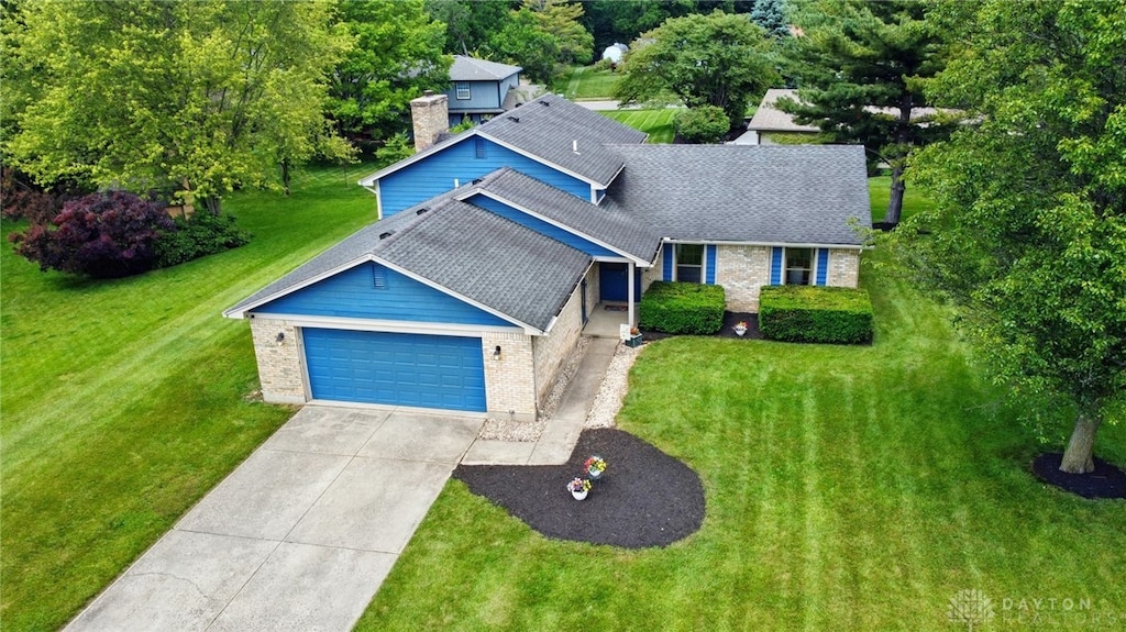 2565 Chess Wood Pt, Washington Twp, OH 45458 - view of front of house with brick siding, an attached garage, driveway, and a front lawn
