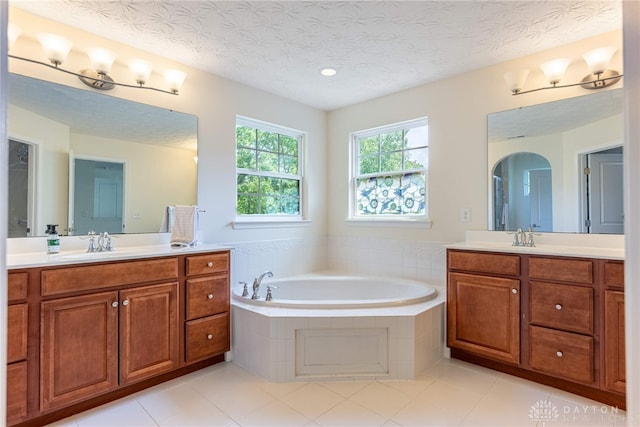 8730 Dowd Ct, Washington Twp, OH 45458 - bathroom featuring two vanities, a bath, tile patterned flooring, a textured ceiling, and recessed lighting