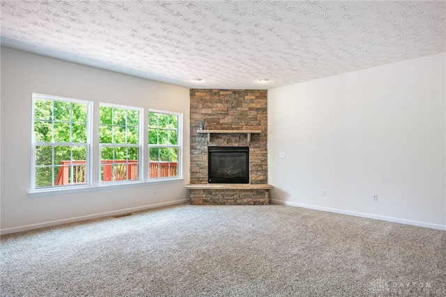 8730 Dowd Ct, Washington Twp, OH 45458 - unfurnished living room with carpet flooring, a textured ceiling, a stone fireplace, and baseboards