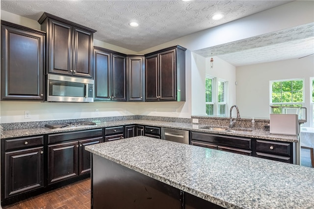 8730 Dowd Ct, Washington Twp, OH 45458 - kitchen featuring stainless steel appliances, a sink, dark wood-style flooring, light stone counters, and recessed lighting