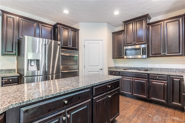 8730 Dowd Ct, Washington Twp, OH 45458 - kitchen with appliances with stainless steel finishes, light stone countertops, dark wood-style flooring, dark brown cabinetry, and recessed lighting