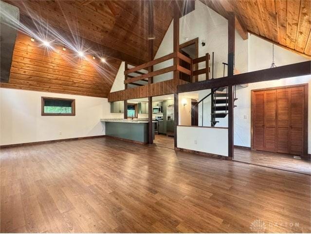 5565 Short Rd, New Carlisle, OH 45344 - unfurnished living room with high vaulted ceiling, wooden ceiling, wood finished floors, stairway, and baseboards