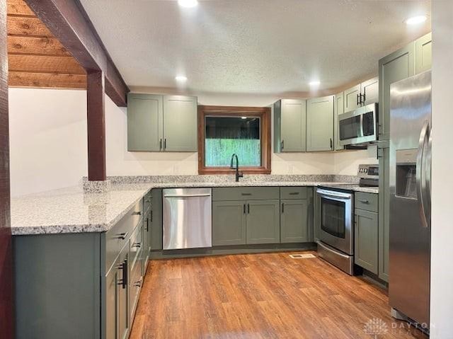 5565 Short Rd, New Carlisle, OH 45344 - kitchen featuring stainless steel appliances, green cabinets, light wood-style floors, and recessed lighting