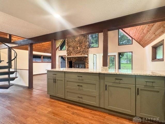 5565 Short Rd, New Carlisle, OH 45344 - kitchen featuring light wood-style flooring, light stone counters, a textured ceiling, open floor plan, and a fireplace
