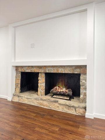 5565 Short Rd, New Carlisle, OH 45344 - detailed view of a stone fireplace, baseboards, and wood finished floors