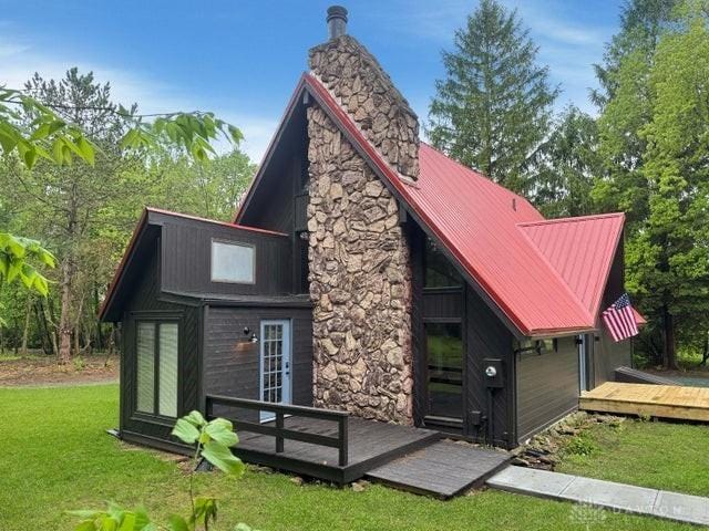 5565 Short Rd, New Carlisle, OH 45344 - back of property with a wooden deck, a lawn, a chimney, and metal roof