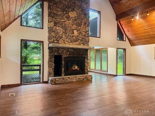 5565 Short Rd, New Carlisle, OH 45344 - unfurnished living room featuring high vaulted ceiling, wooden ceiling, baseboards, wood finished floors, and a stone fireplace