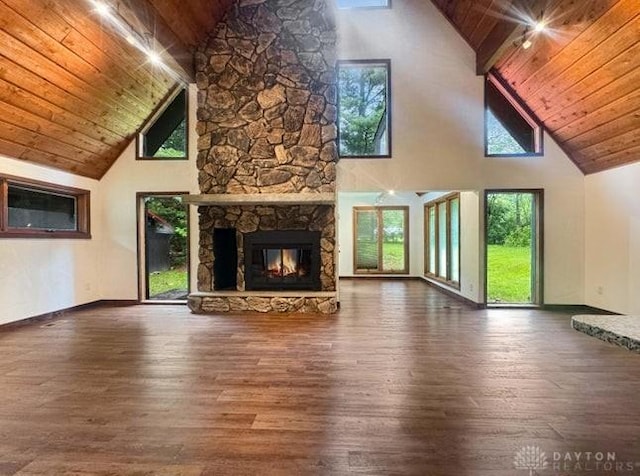 5565 Short Rd, New Carlisle, OH 45344 - unfurnished living room featuring high vaulted ceiling, wooden ceiling with exposed beams, wood finished floors, plenty of natural light, and a stone fireplace