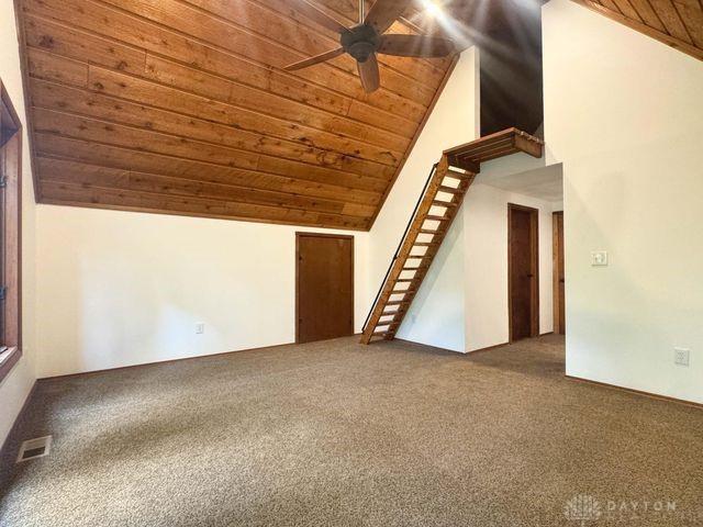 5565 Short Rd, New Carlisle, OH 45344 - unfurnished living room with wood ceiling, lofted ceiling, a ceiling fan, and carpet flooring