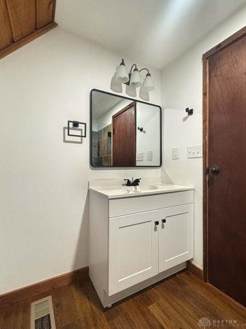 5565 Short Rd, New Carlisle, OH 45344 - bathroom with vanity, wood finished floors, and baseboards