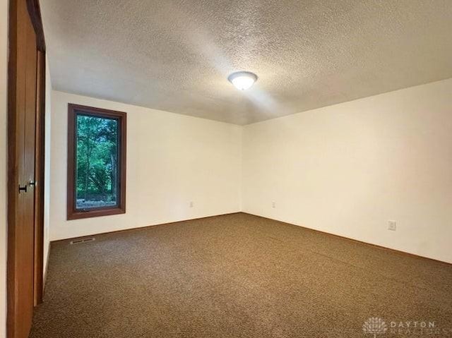5565 Short Rd, New Carlisle, OH 45344 - spare room with dark colored carpet and a textured ceiling