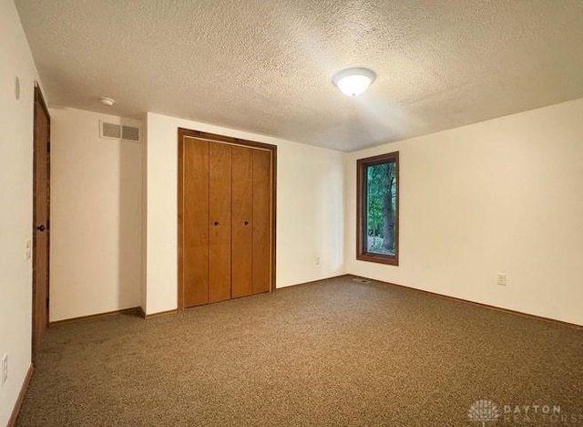 5565 Short Rd, New Carlisle, OH 45344 - unfurnished bedroom featuring a textured ceiling, carpet, a closet, and baseboards