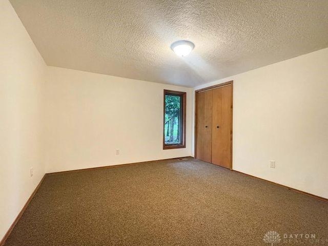 5565 Short Rd, New Carlisle, OH 45344 - spare room featuring a textured ceiling and carpet