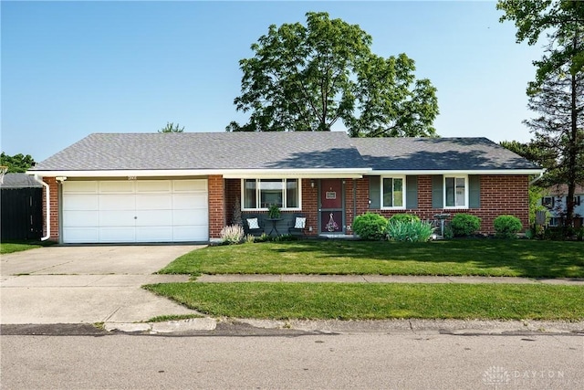 2801 Pinegrove Dr, Dayton, OH 45449 - ranch-style house with driveway, brick siding, an attached garage, a front lawn, and covered porch