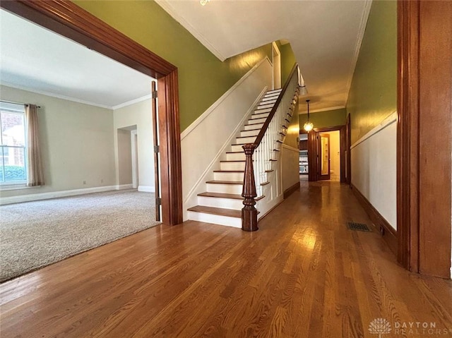 142 W Church St, Xenia, OH 45385 - staircase with crown molding, wood finished floors, baseboards, and a chandelier
