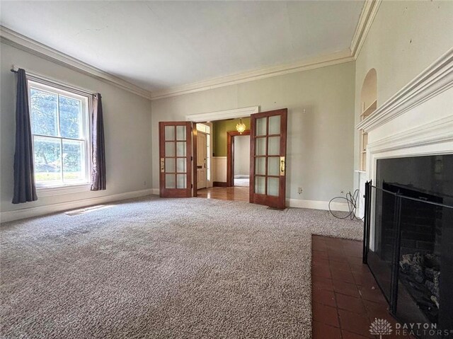 142 W Church St, Xenia, OH 45385 - unfurnished living room featuring dark colored carpet, french doors, a fireplace with flush hearth, crown molding, and baseboards
