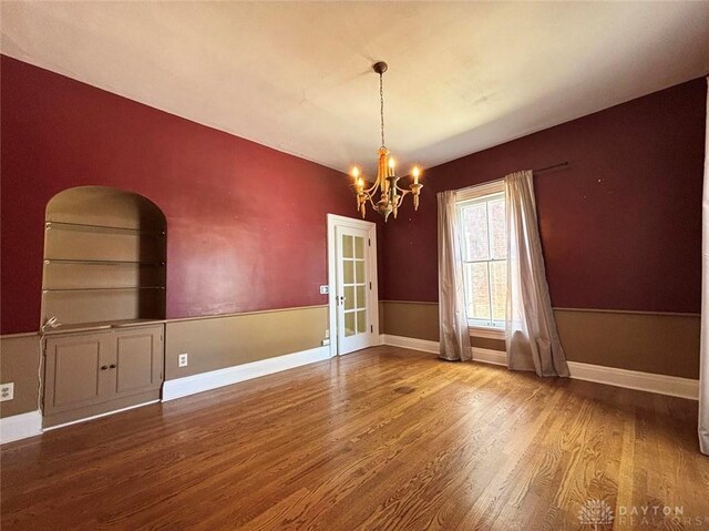 142 W Church St, Xenia, OH 45385 - unfurnished dining area featuring wood finished floors, a chandelier, and baseboards