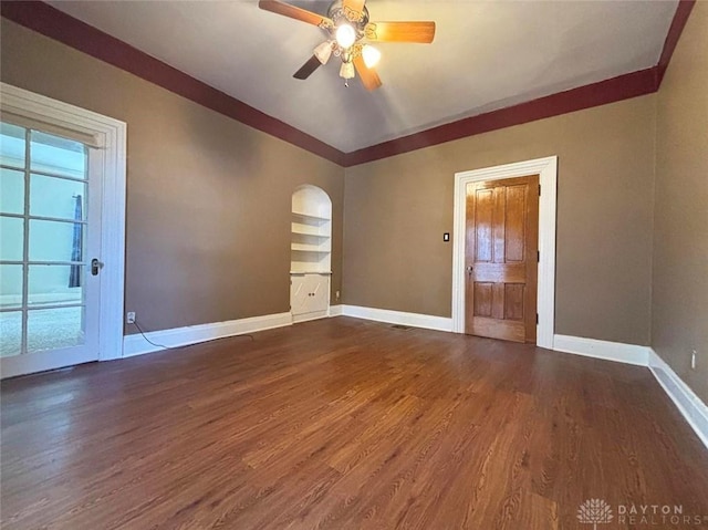 142 W Church St, Xenia, OH 45385 - unfurnished room featuring wood finished floors, baseboards, arched walkways, ceiling fan, and plenty of natural light