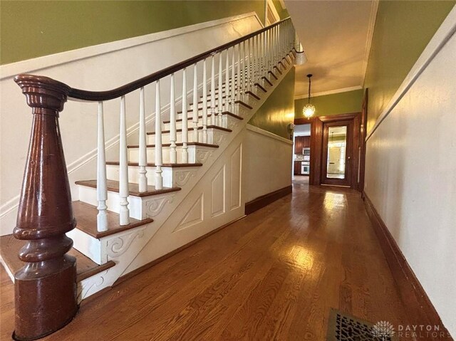 142 W Church St, Xenia, OH 45385 - stairs featuring wood finished floors, crown molding, and baseboards